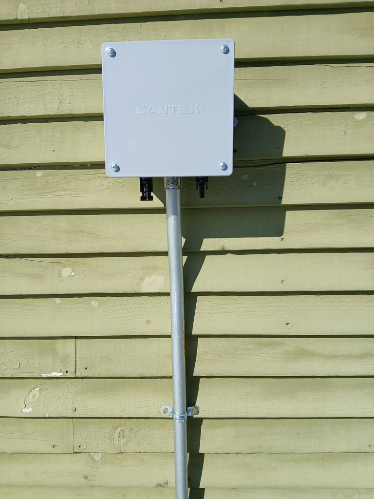 White Lantex electrical box mounted on a pale green wooden wall with a metal pole and bracket support